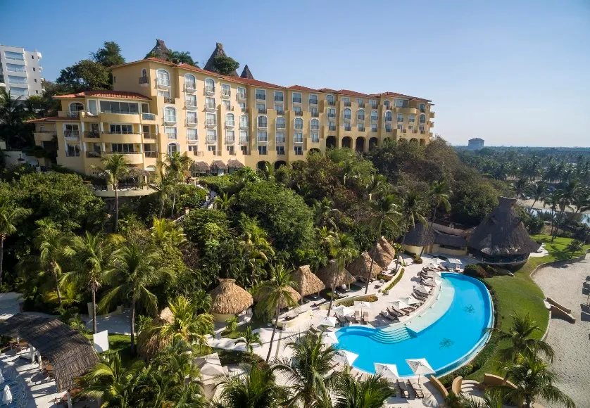 Resort hotelero sobre la ladera con albercas y vegetación tropical